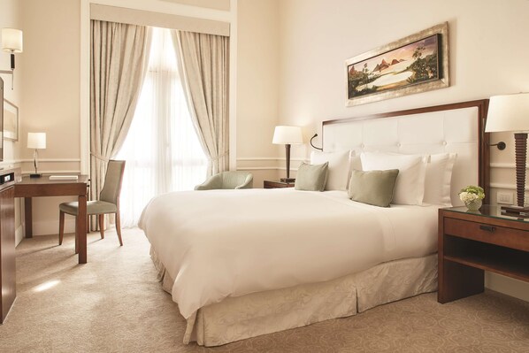 A hotel room with a large bed, two bedside tables, a desk with a chair, a window with curtains, and a painting on the wall. - Copacabana Palace, A Belmond Hotel, Rio de Janeiro (Rio de Janeiro)