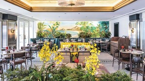 A restaurant with a tropical mural, wooden ceiling, and various seating arrangements.