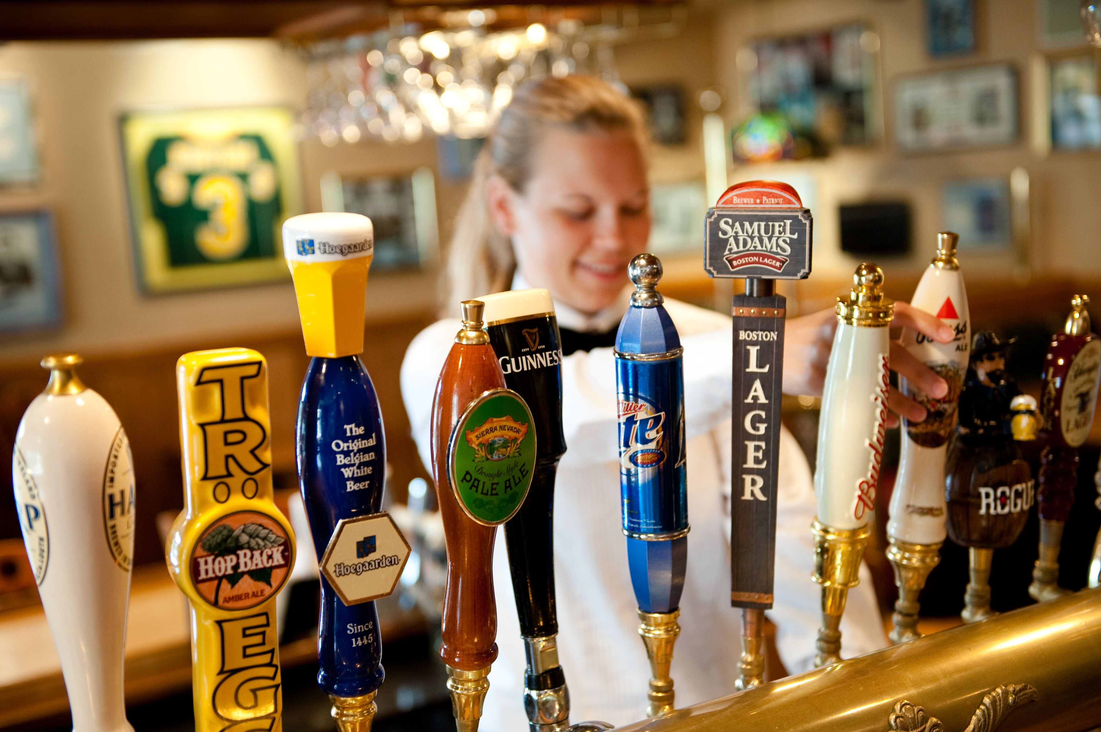 Een bar met verschillende biertaps, waaronder merken als Samuel Adams en Guinness.