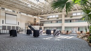 Un vaste espace intérieur doté d’un haut plafond, de plusieurs niveaux et d’un escalier central.