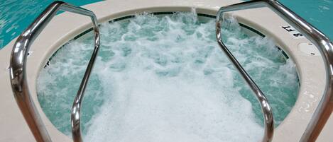 A hot tub with metal railings and a visible water level indicator.