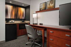 A compact hotel room with a kitchenette, a desk with a chair, a flat-screen TV, and artwork on the wall. - Courtyard Fremont Silicon Valley (Fremont)
