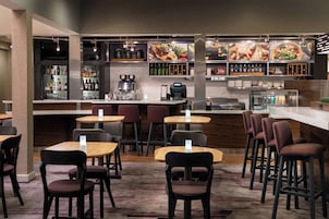 A modern bar area with seating and a coffee machine.