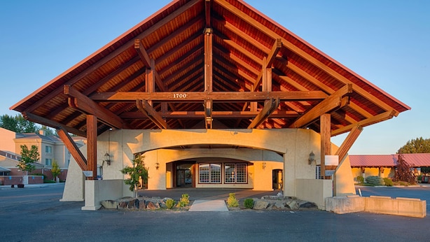 A large building with a prominent wooden roof structure and a central entrance. - Red Lion Hotel & Conference Center Ellensburg (Ellensburg)