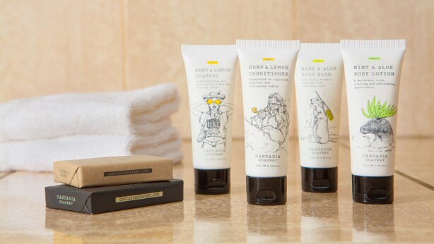 Four tubes of Cascadia Soapery products and two soap bars on a bathroom counter.