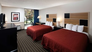 A hotel room with two beds, a desk with a computer, a TV, and a window with a view of trees. - Red Lion Hotel & Conference Center Ellensburg (Ellensburg)
