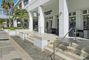 Stylish building with a Starbucks Coffee sign above the entrance, featuring a clean design and outdoor seating areas. at The Condado Plaza Hotel