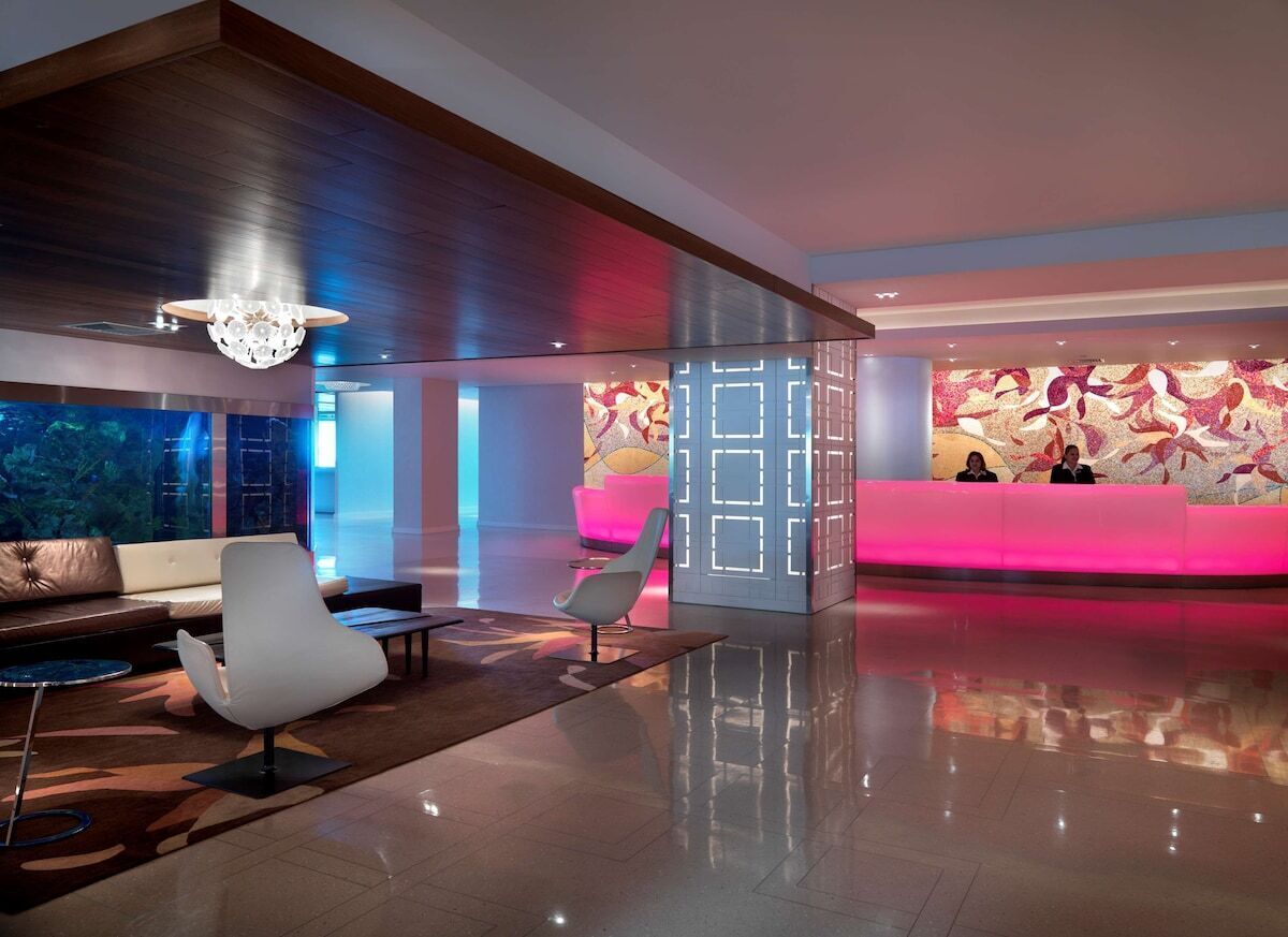 A modern lobby with a reception desk, seating area, and a large aquarium.