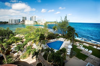 Relax by the infinity pool overlooking the ocean and city skyline. at The Condado Plaza Hotel