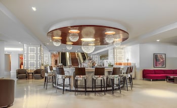 Relax in style with a central bar area surrounded by cushioned stools and leather sofas. at The Condado Plaza Hotel