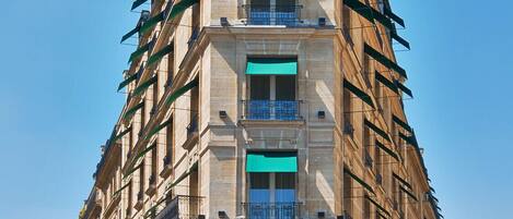 Un hôtel à plusieurs étages doté d’une architecture originale, caractérisé par un toit arrondi et une série de balcons.
