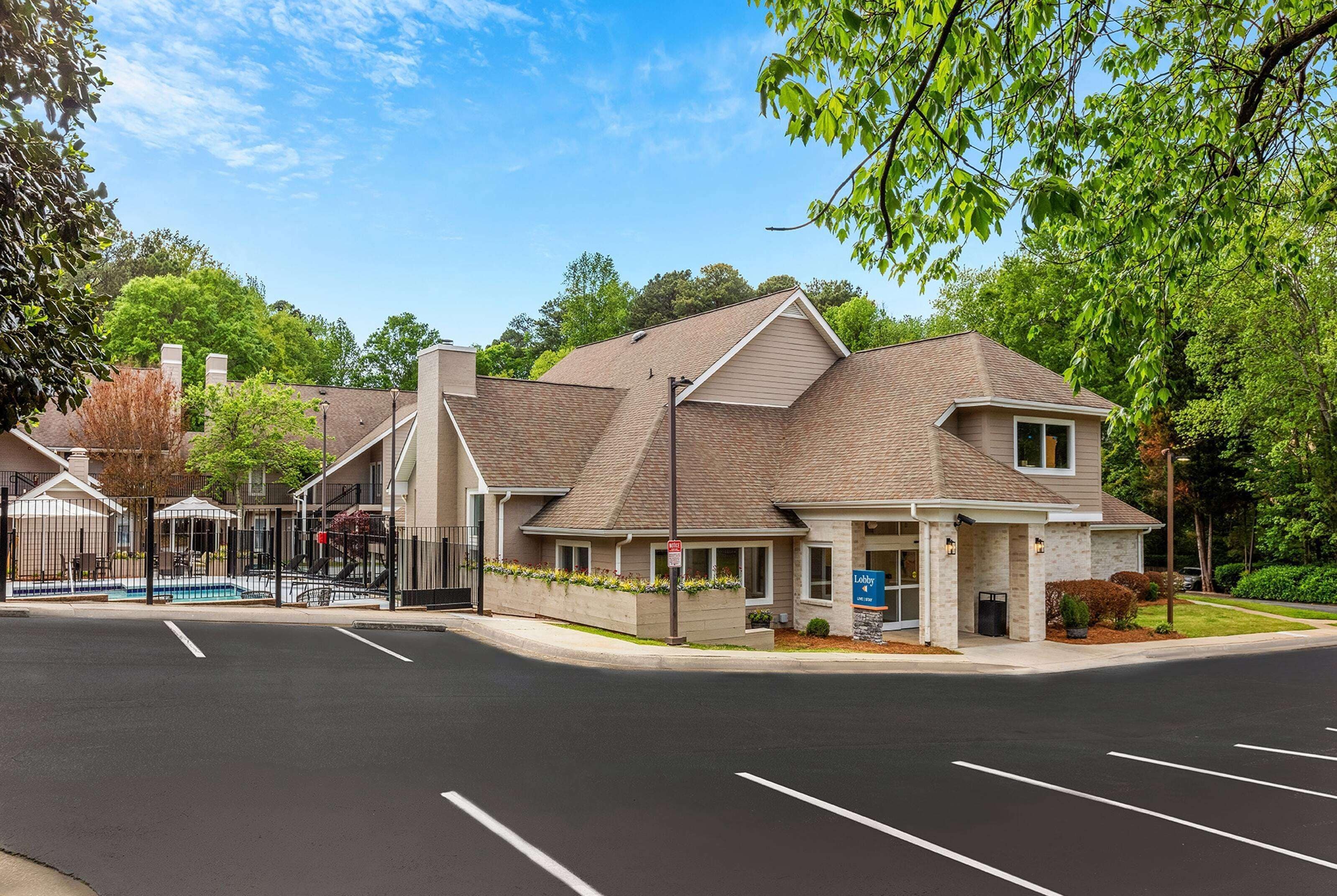 A multi-story building with a parking lot in front.
