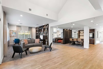 A modern bedroom with a large bed, a wooden headboard, and a nightstand. at WaterWalk Extended Stay by Wyndham Atlanta Perimeter