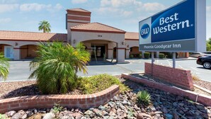 Un hotel Best Western Phoenix Goodyear Inn con tejado de tejas rojas, fachada de ladrillo y un cartel.
