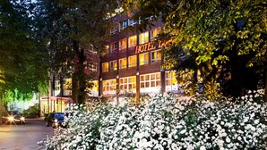 A hotel with multiple floors, large windows, and a well-lit facade. - Hotel Domicil Hamburg by Golden Tulip (Hamburg)