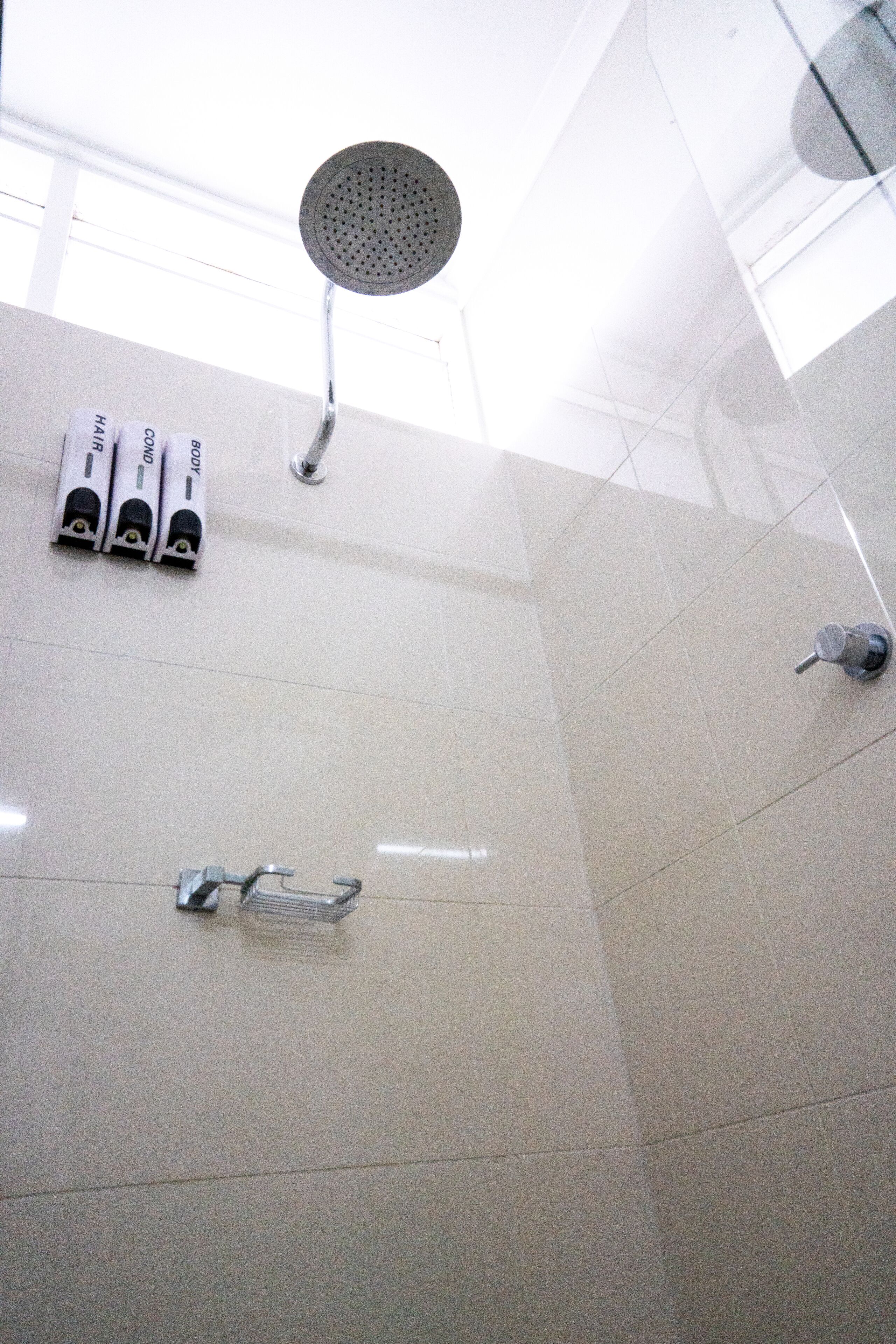 A modern bathroom with a shower, toilet, and hand dryer.