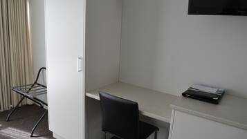 Ett litet, privat kontor med ett skrivbord, en stol, ett element och en tv som är monterad på väggen.