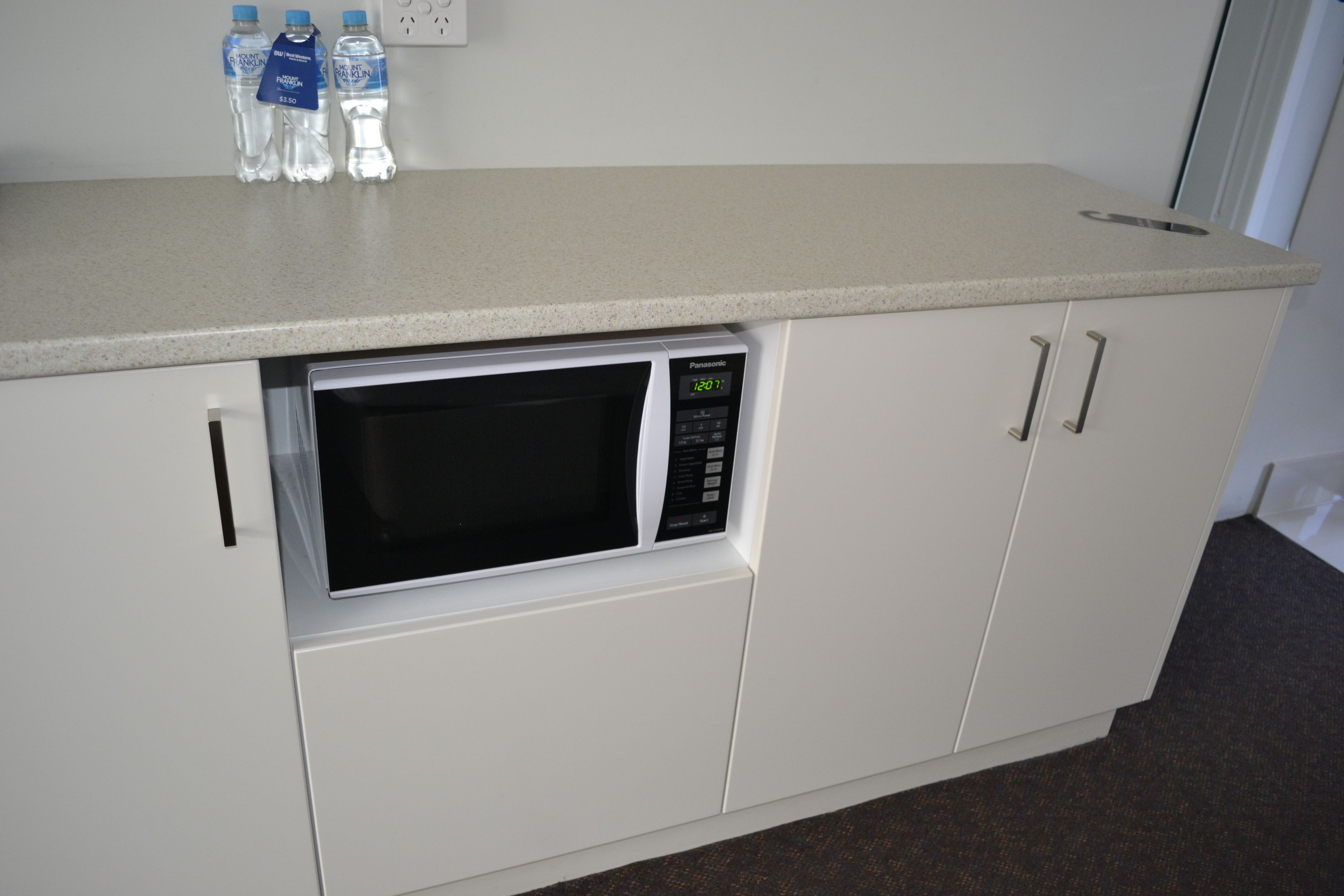 A kitchenette with a microwave, a water dispenser, and a sink.
