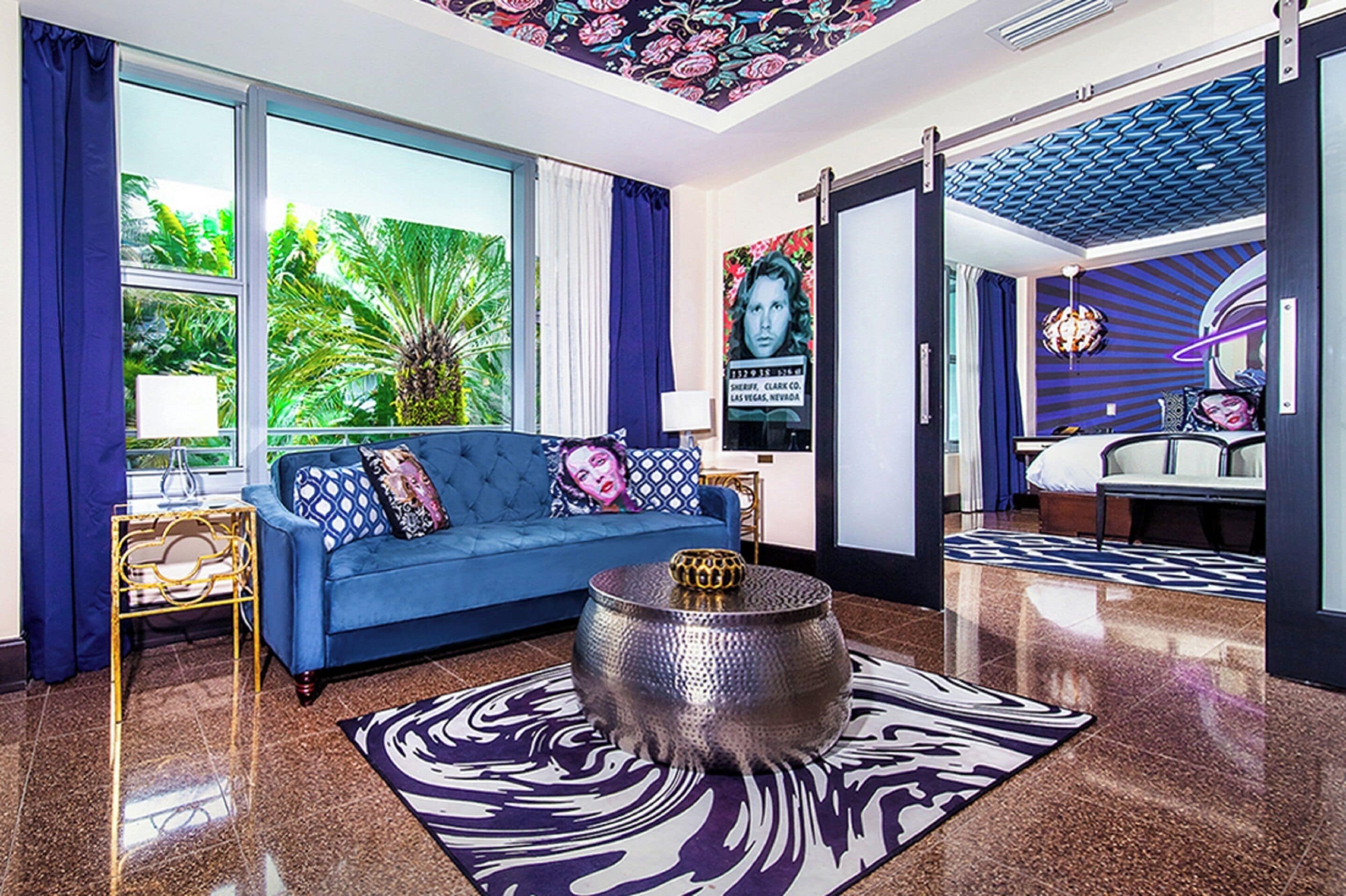 Una sala de estar moderna con un sofá azul, un tapete estampado y una mesa de centro decorativa.