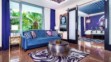 Una sala de estar moderna con un sofá azul, un tapete estampado y una mesa de centro decorativa.