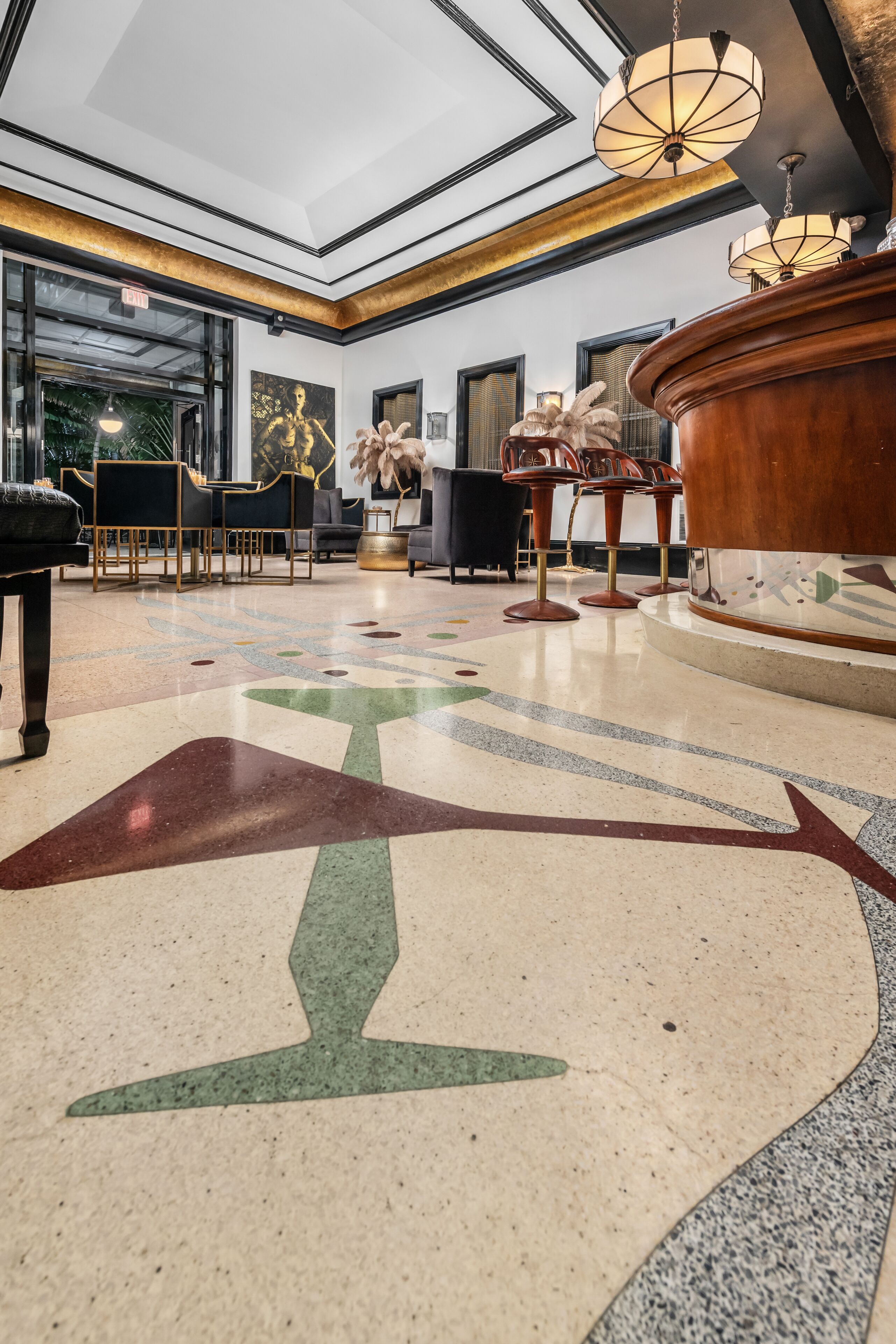 A spacious lobby with a high ceiling, a patterned floor, and a central wooden table with chairs.