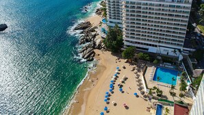 Un hotel con piscina, playa y vista al océano.