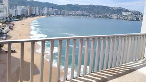 Un balcón con vista a la playa y al paisaje urbano.