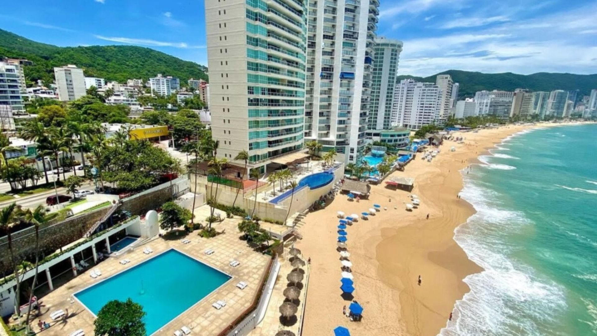 A coastal hotel with a pool, beach, and ocean view.