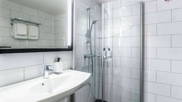 Een moderne badkamer met een wit wastafelmeubel, een douchecabine met glazen wanden en een spiegel boven het wastafelmeubel.