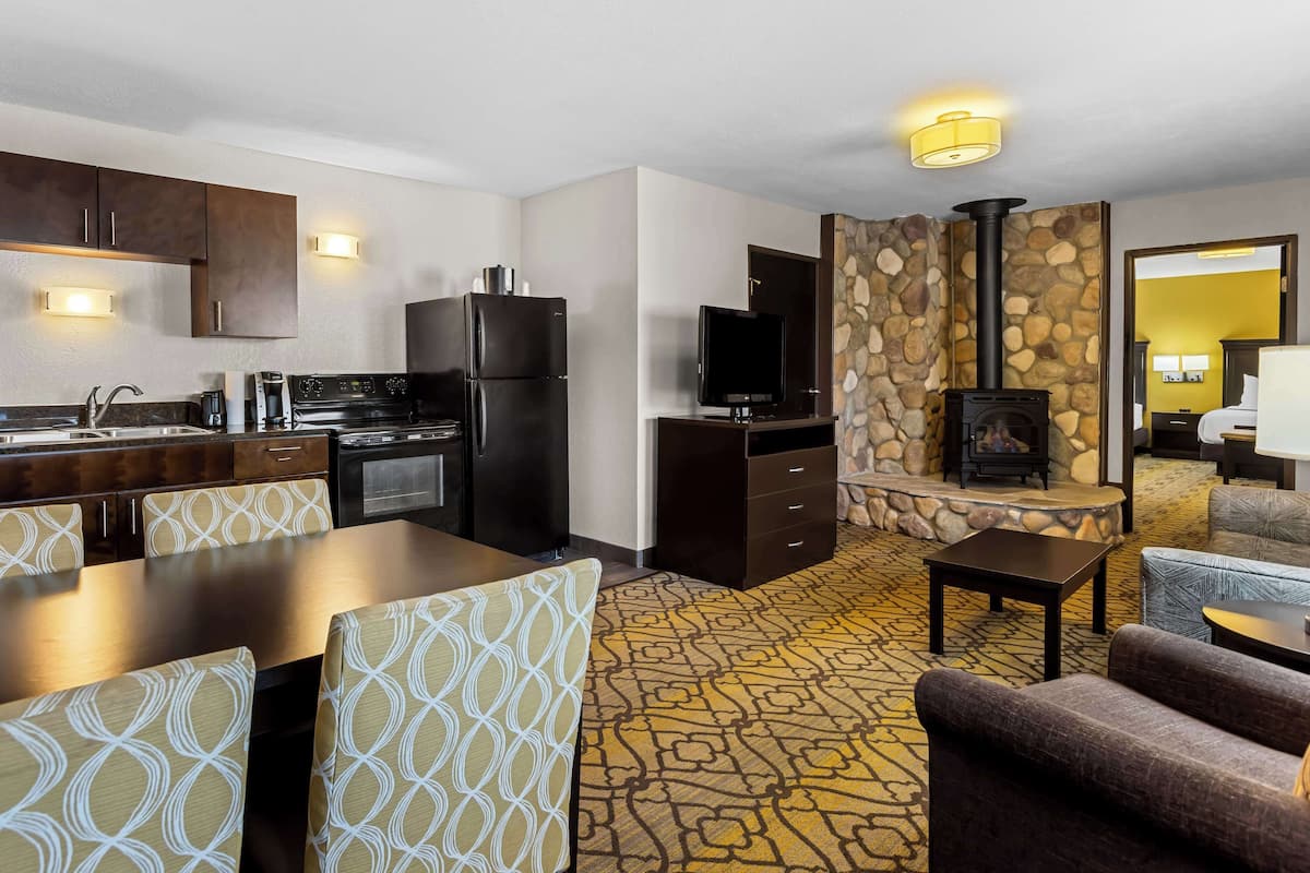 A modern hotel room with a kitchen, dining area, and living space.