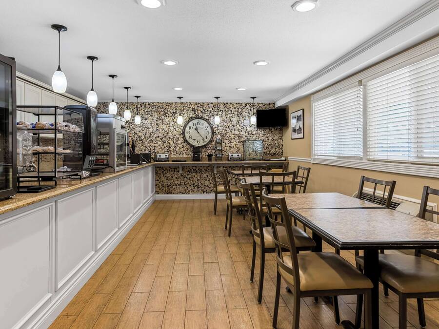Ein Restaurant mit Küchenzeile, Holzboden und einer Uhr an der Wand.