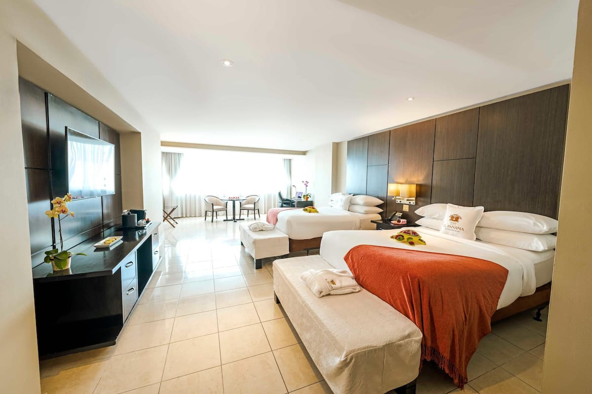 Una habitación de hotel moderna con una cama grande, un escritorio, un televisor y un comedor.