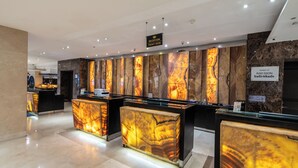 A reception area with marble reception desks and a sign indicating the reception desk.