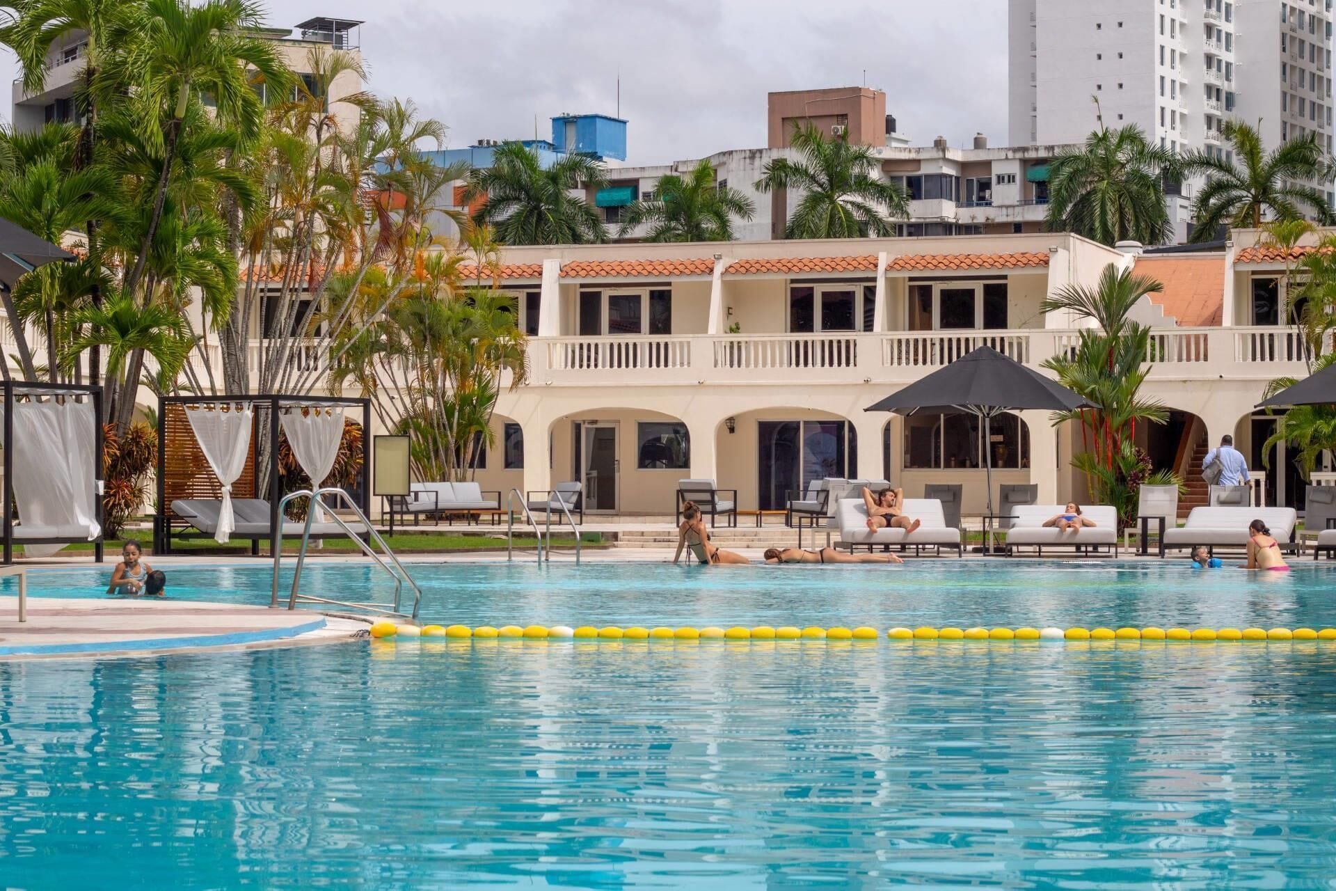 Una piscina al aire libre, camas de piscina gratis, sombrillas