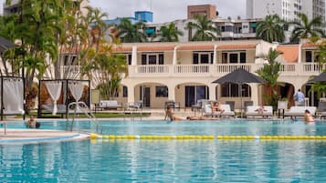 Una piscina al aire libre, camas de piscina gratis, sombrillas