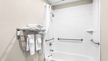 Un baño con bañera, ducha y un tendedero con toallas dobladas.