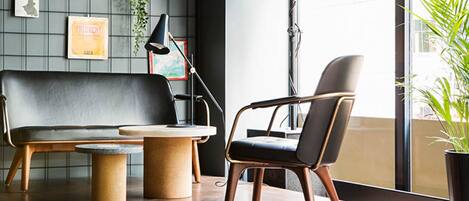 A modern living room with a sofa, a chair, a coffee table, and a TV mounted on the wall.
