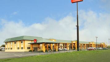 A hotel with a green roof, multiple units, and a prominent red sign.