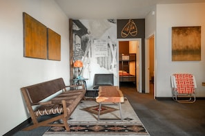 A hallway with a sofa, a chair, a small table, and a ski-themed wall art.