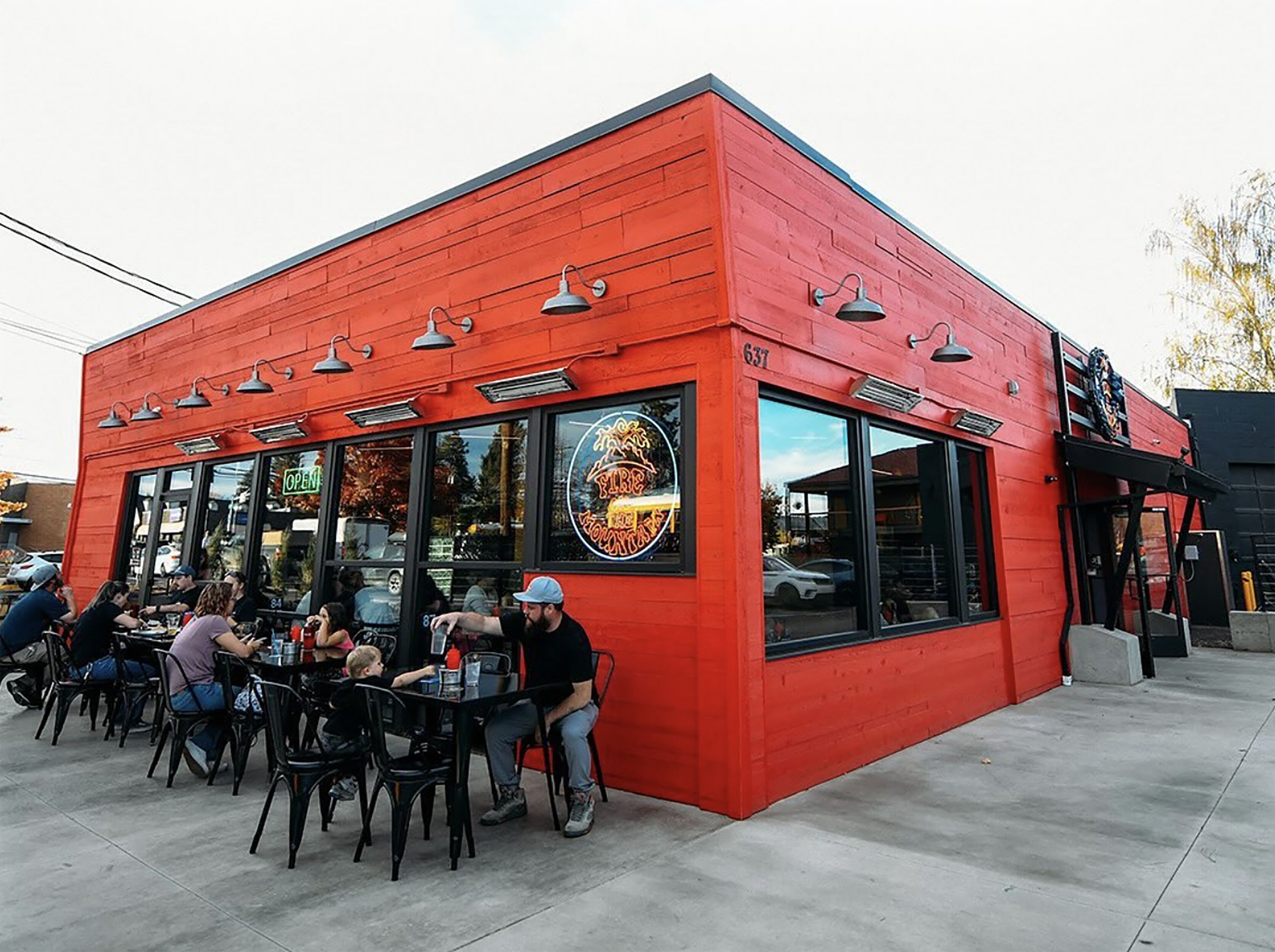 A red building with a storefront and outdoor seating area.