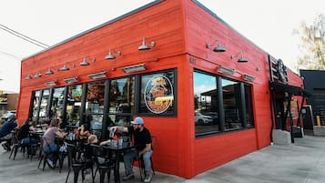 A red building with a storefront and outdoor seating area.