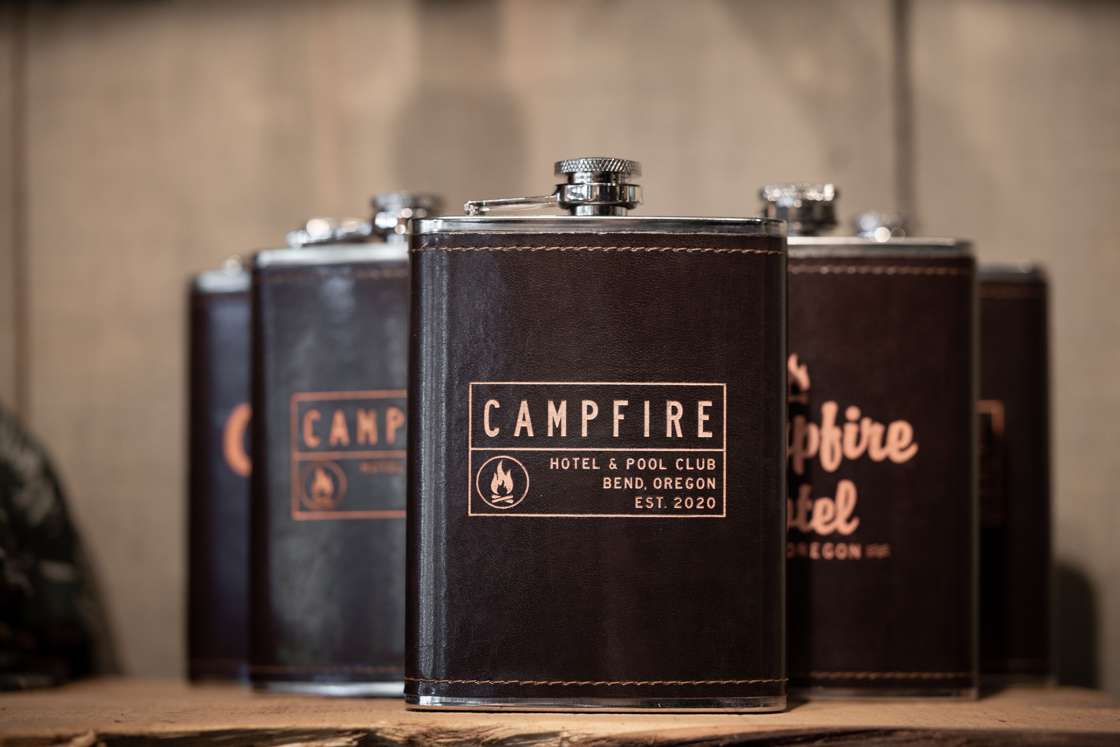 Una hilera de libros encuadernados en cuero negro con el título 'Campfire Hotel & Pool Club Bend, Oregon' y el año de fundación 'EST. 2020'.