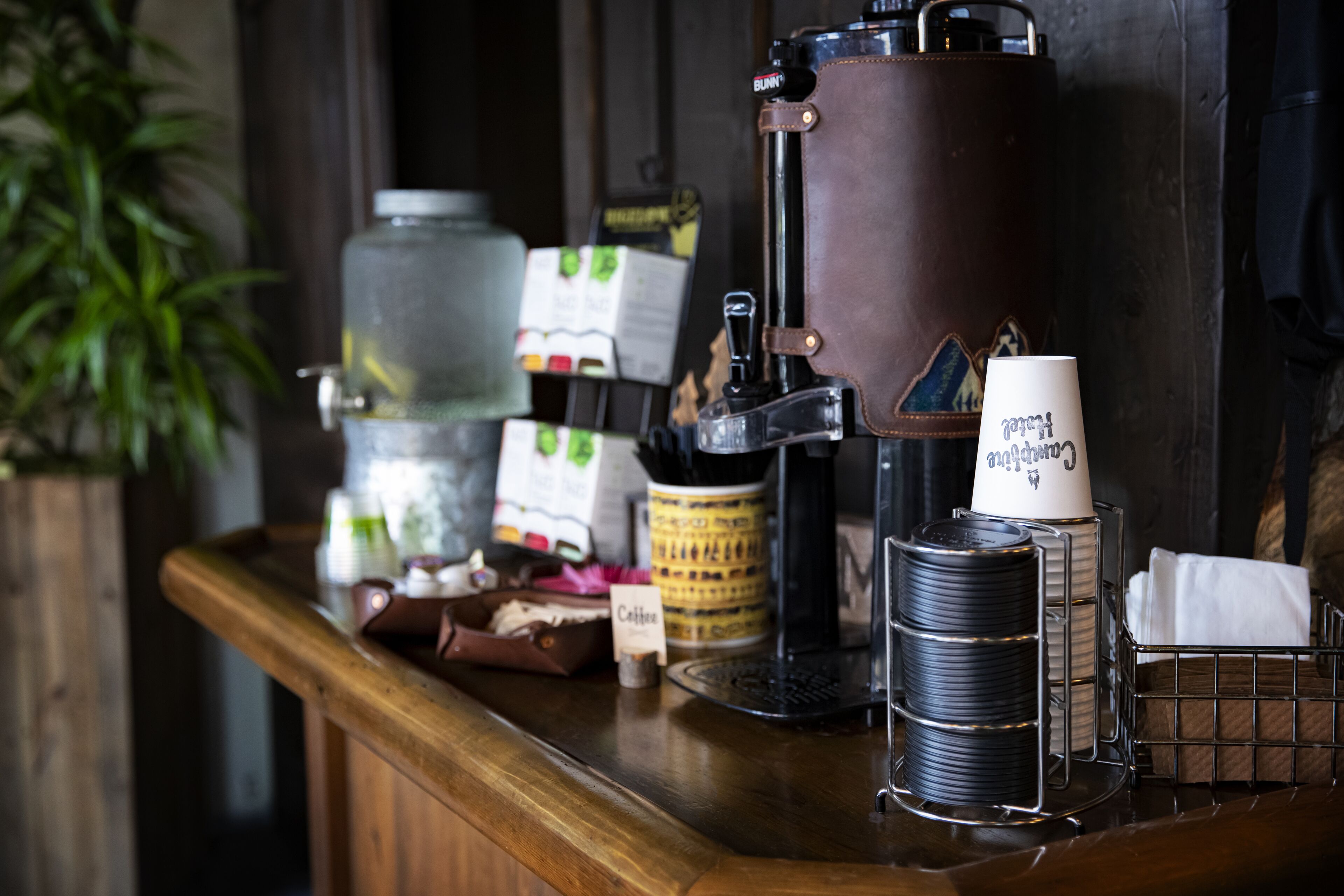 A coffee bar with a coffee grinder, a milk frother, and a coffee cup holder.