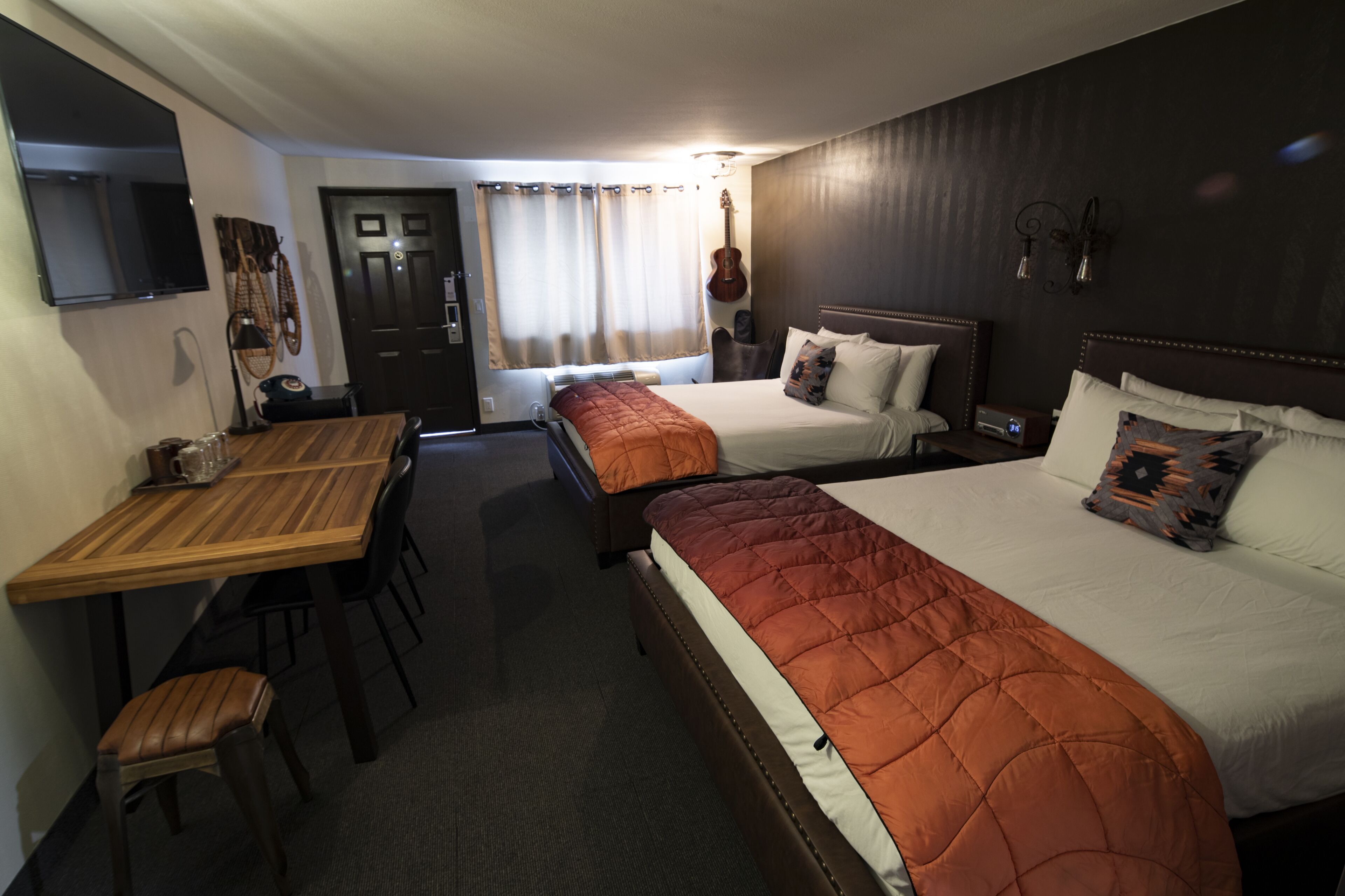 Une chambre d’hôtel avec deux lits, un bureau en bois et une chaise.