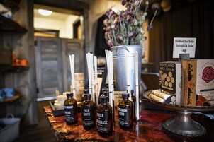 A display of candles and essential oils on a wooden counter.