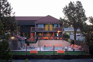 A two-story building with a pool area, outdoor seating, and a balcony.