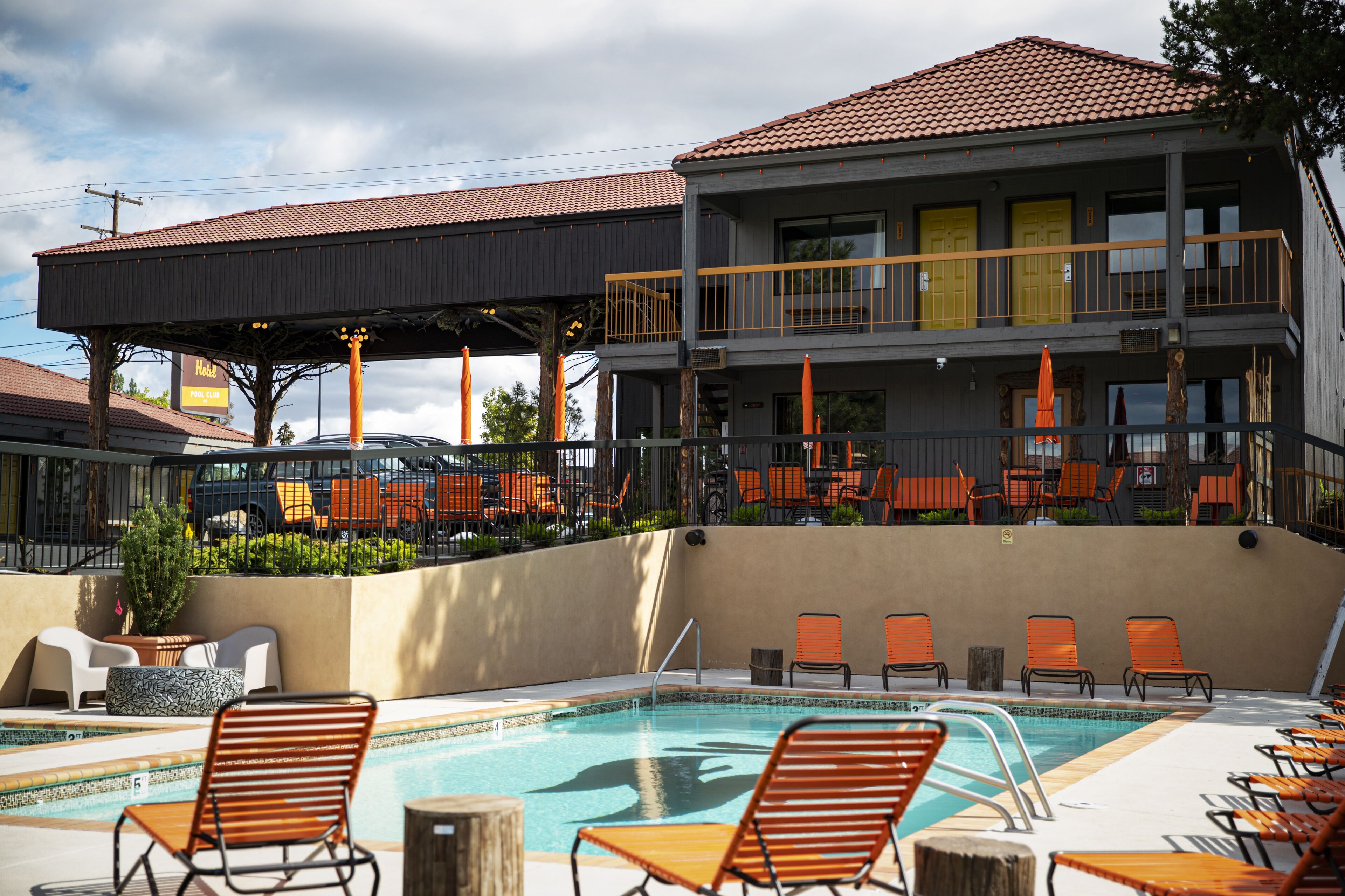A poolside area with multiple lounge chairs and a covered seating area.