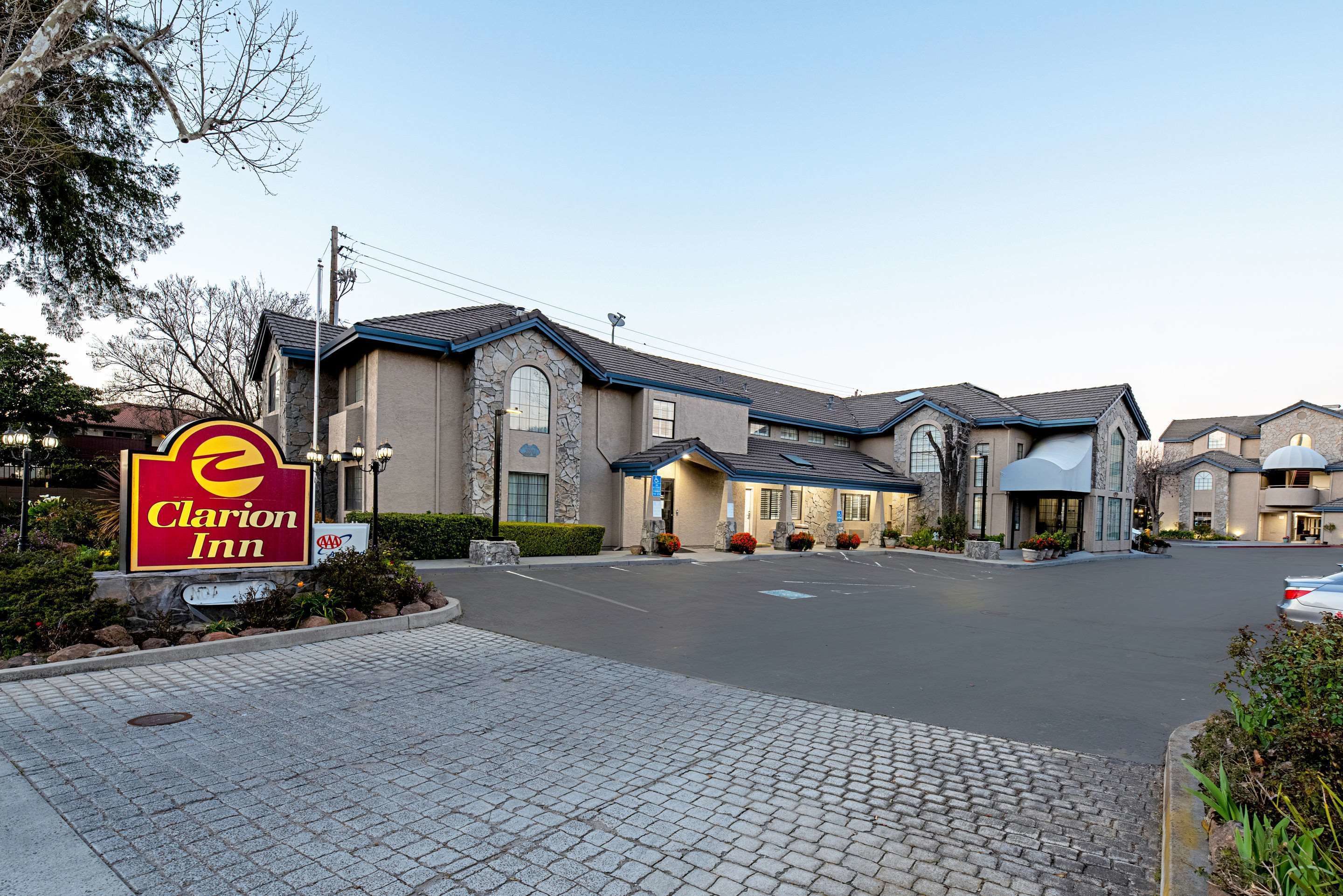 Een Clarion Inn hotel met een stenen gevel, meerdere ingangen en een verharde oprit.