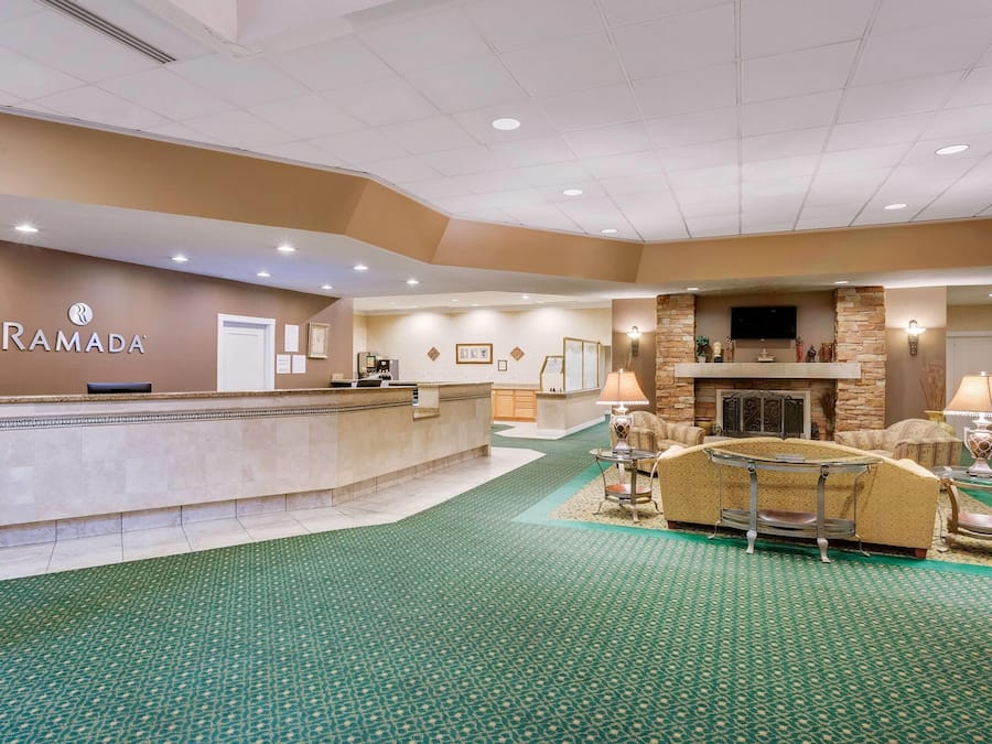 A reception area with a counter, a fireplace, and a seating area with a sofa and armchairs.