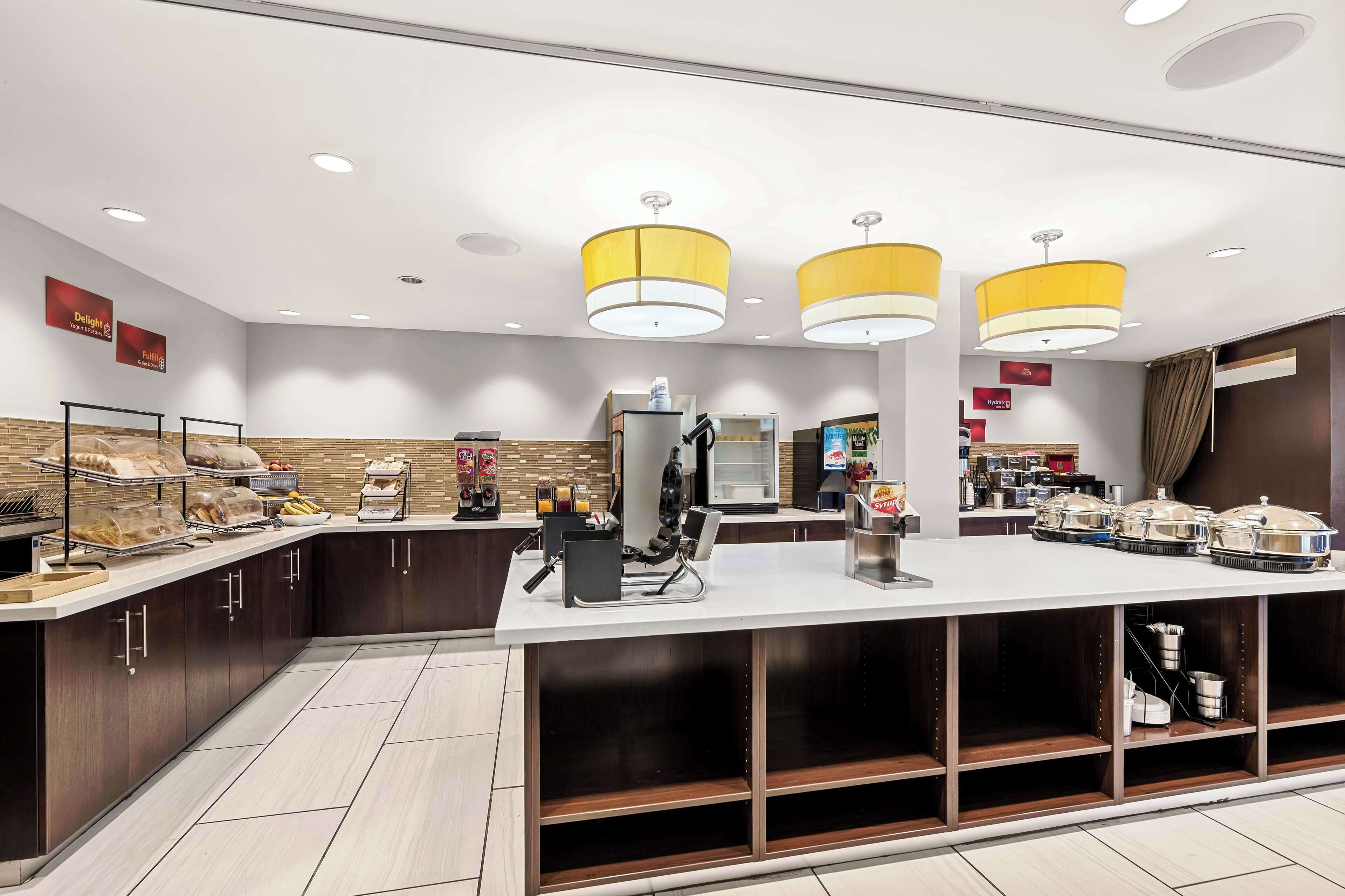 A modern breakfast bar with a variety of food items and a coffee station.
